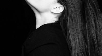 grayscale-photo-of-woman-with-her-eyes-closed-touching-her-2166774