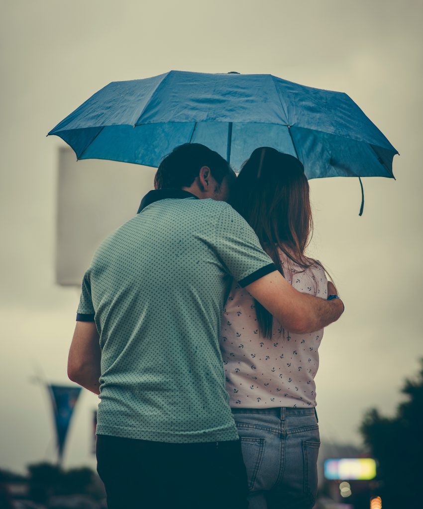 man-hugging-woman-while-holding-umbrella-1534633