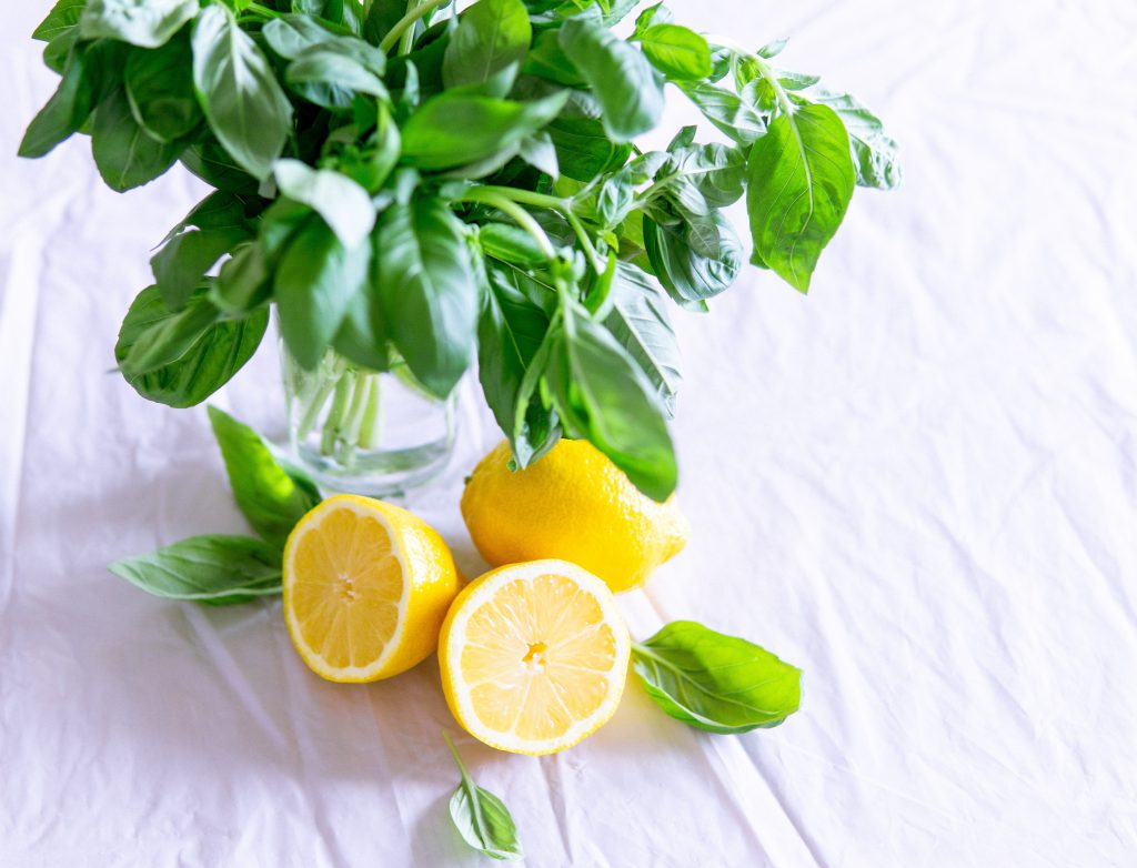 sliced-lemon-and-basil-leaves-on-glass-1585849