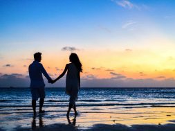 man-and-woman-holding-hands-walking-on-seashore-during-1024960