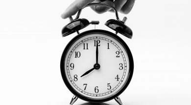 person-touching-black-two-bell-alarm-clock-1198264