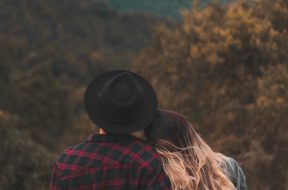 couple-standing-on-top-of-hill-1995718