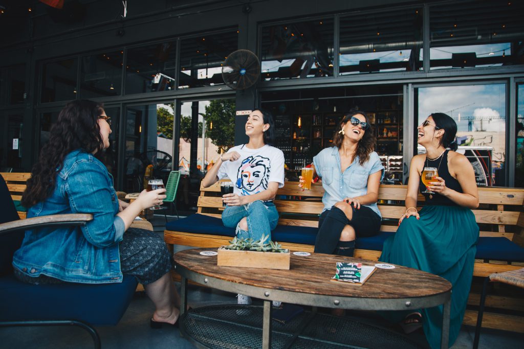four-women-chatting-while-sitting-on-bench-1267697 (1)