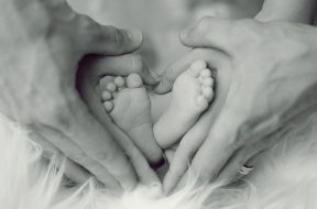 grayscale-photo-of-baby-feet-with-father-and-mother-hands-in-733881 (1)
