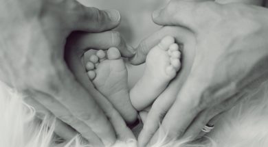 grayscale-photo-of-baby-feet-with-father-and-mother-hands-in-733881