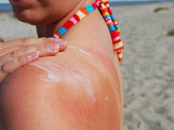 A woman applies sunblock at the beach