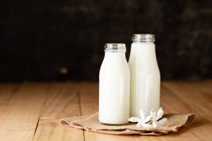 Fresh milk two bottle glass on the wooden table Black background