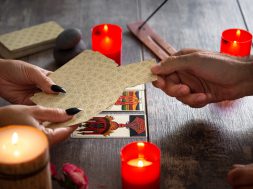 Fortune teller reading a future by tarot cards on rustic table