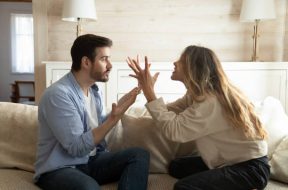 Emotional annoyed stressed couple sitting on couch, arguing at home. Angry irritated nervous woman man shouting at each other, figuring out relations, feeling outraged, relationship problems concept.