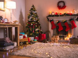 Christmas tree with presents near the fireplace at home in the living room