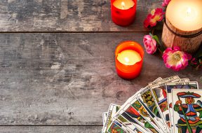 Tarot cards on wooden table with candles