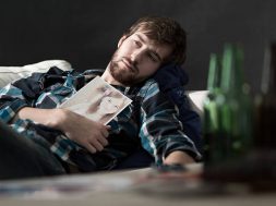 Depressed man drinking beers after split up