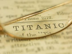 The word, Titanic, on a 1912 newspaper with antique gold glasses. The newspaper does not exist anymore and closed in the 1930's.