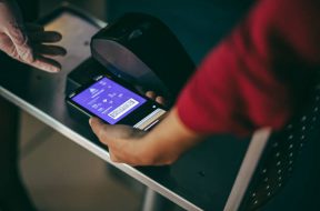 Unrecognizable woman scans smart phone at airport check in. Digital scanning on boarding pass at airport check in counter.
