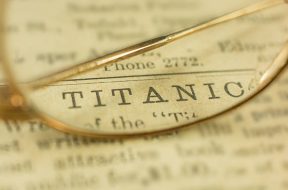 The word, Titanic, on a 1912 newspaper with antique gold glasses. The newspaper does not exist anymore and closed in the 1930's.